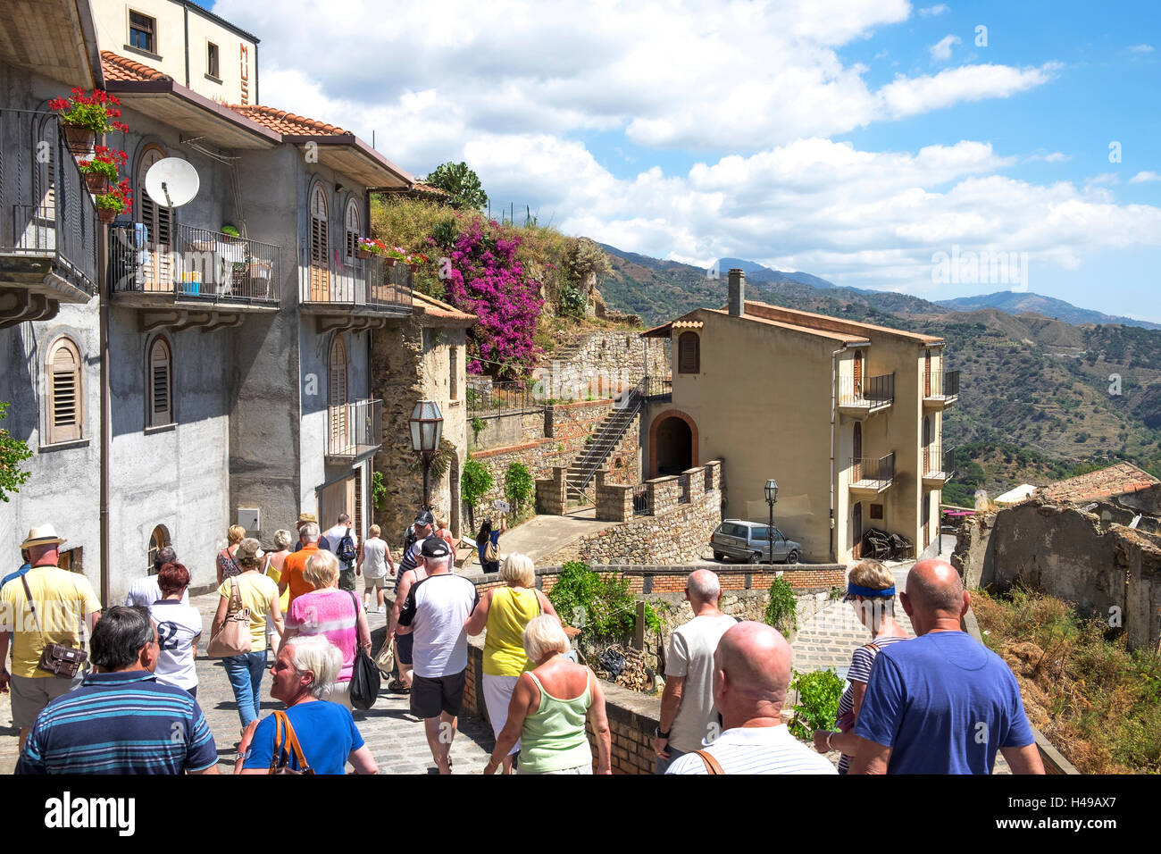 Un groupe de touristes en visite dans le village de montagne de Savoca sur l'île de la Sicile, en Italie. Banque D'Images