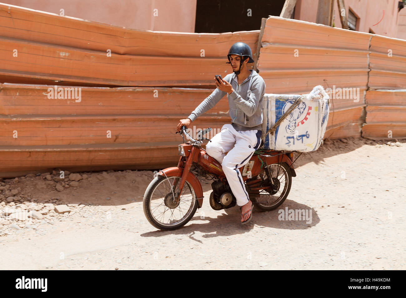 L'homme est une circonscription tout en moto texting, Marrakech, Maroc Banque D'Images