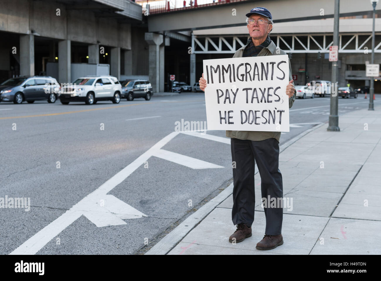 Cincinnati, OH, USA. 13 octobre, 2016. Un homme qui protestent contre l'atout de Donald's Rallye avec un écriteau "les immigrés paient des impôts il n'a pas' à Cincinnati, Ohio. Credit : Caleb Hughes/Alamy Live News. Banque D'Images