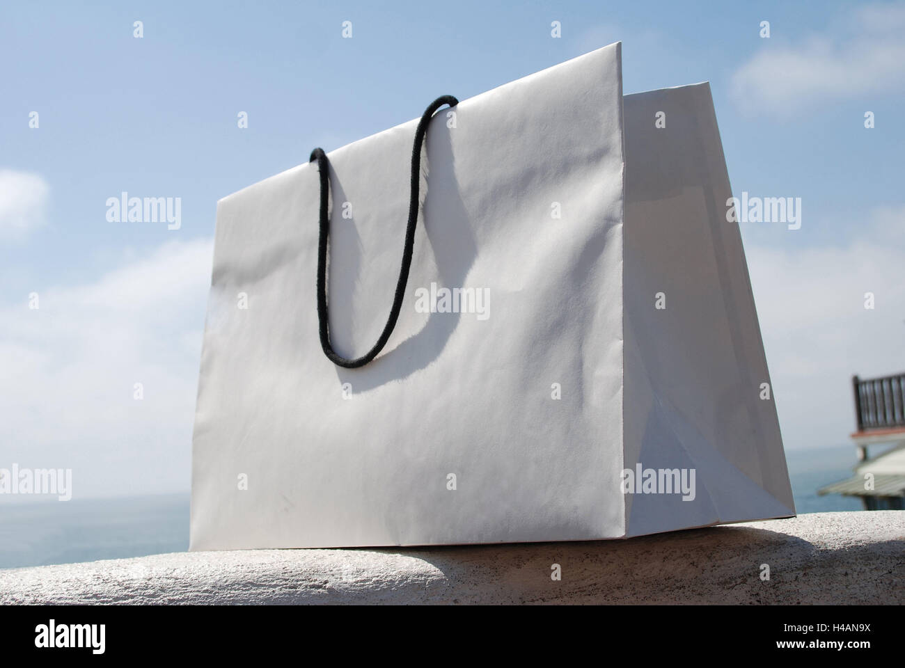 Sac, sac de shopping, mur, ciel, en plein air, l'été, blanc, symbole, l'achat, l'achat, shopping, sac en papier, sac, pose, l'oubli, vol, imprudents, seulement, des boucles, des poignées, cordon, pas de gens, Banque D'Images