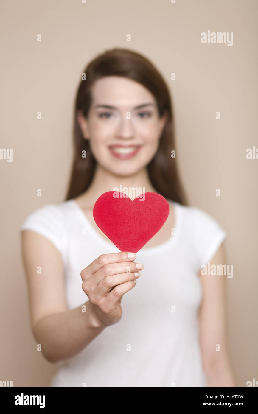 Femme coeur rouge dans sa main, happ, sourire, portrait, faible profondeur de champ, Banque D'Images
