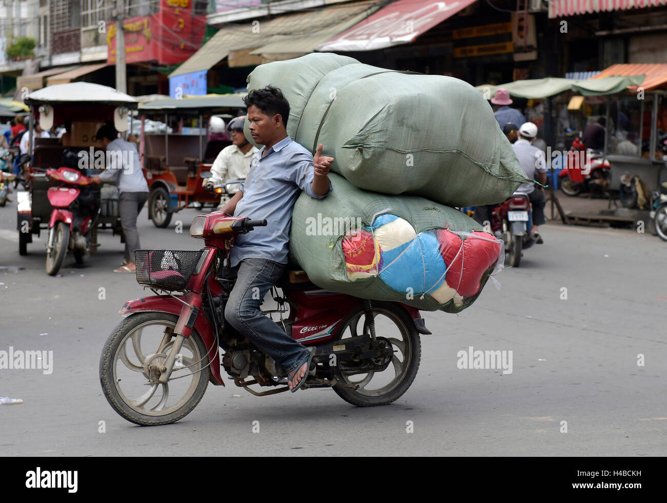 Homme avec un cyclomoteur et grands sacs, Phnom Penh, Cambodge Banque D'Images