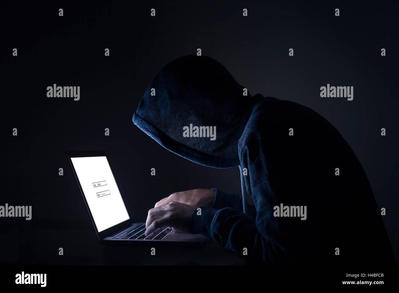 Hacker effectuant une attaque cybernétique on laptop Banque D'Images