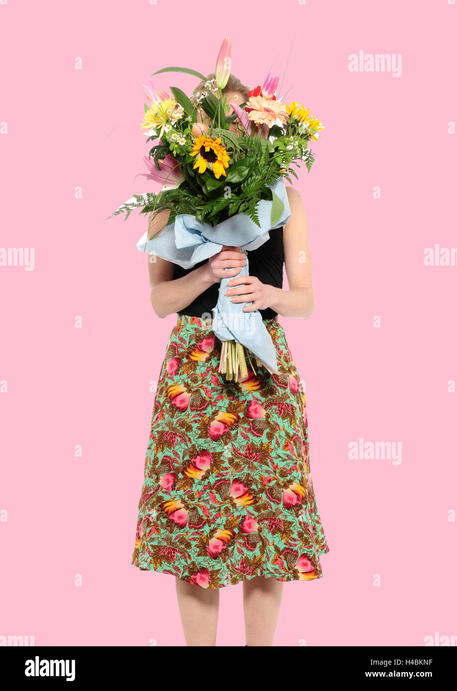 Femme avec bouquet devant son visage, Banque D'Images