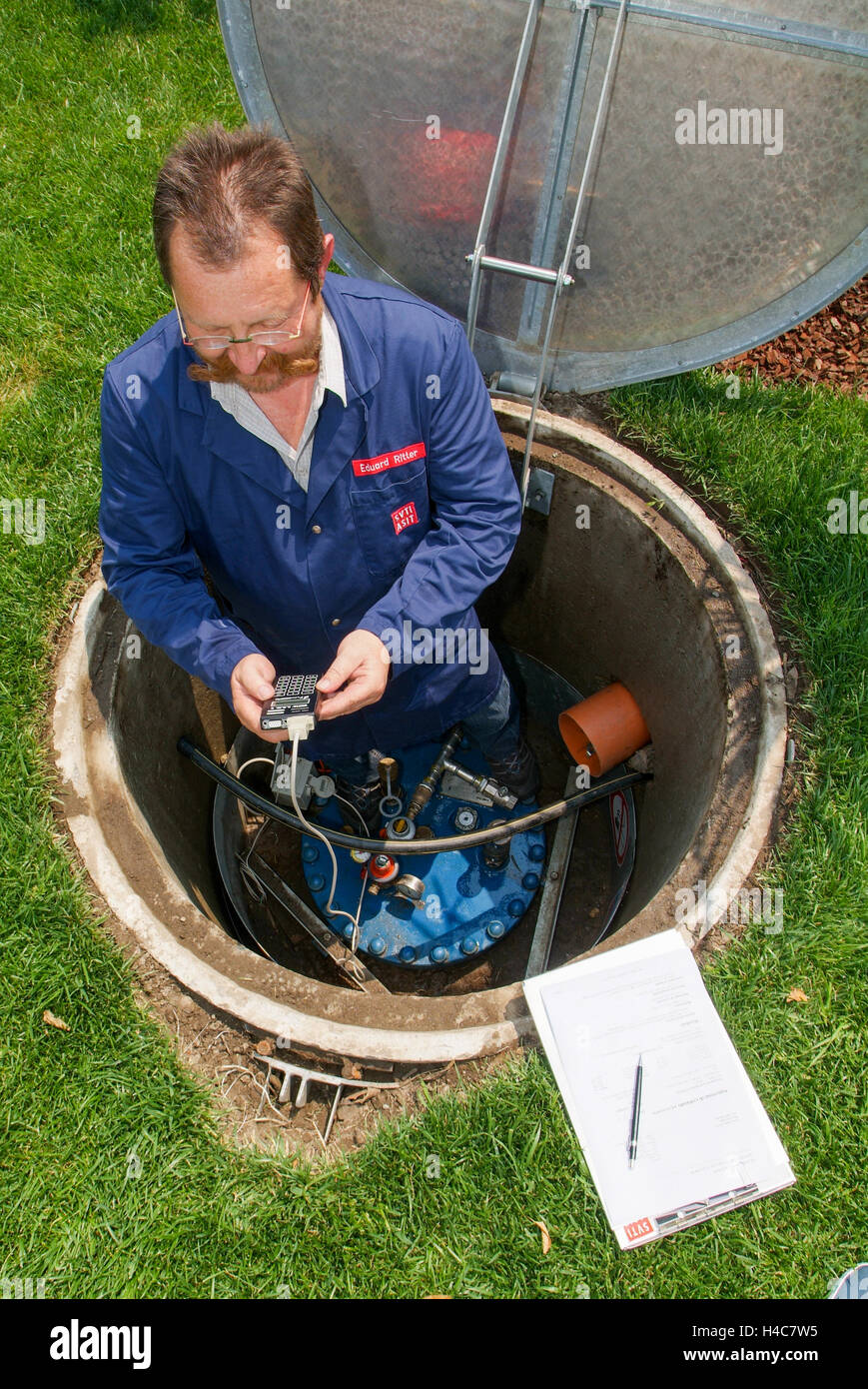 Lugano, Suisse - 3 juin 2005 : Technicien en facilitant la maintenance à un réservoir de gaz sur le jardin d'une maison Banque D'Images