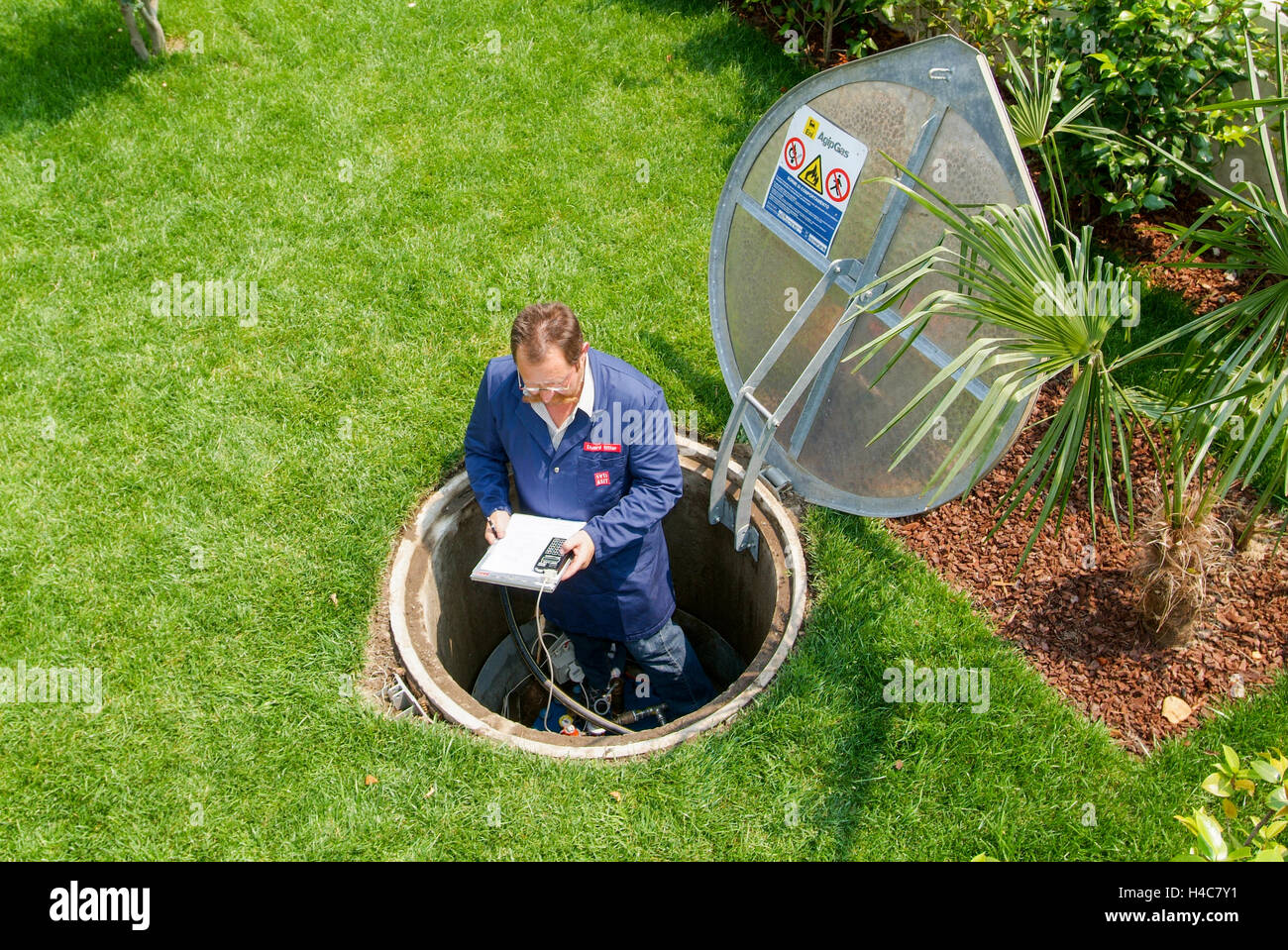Lugano, Suisse - 3 juin 2005 : Technicien en facilitant la maintenance à un réservoir de gaz sur le jardin d'une maison Banque D'Images