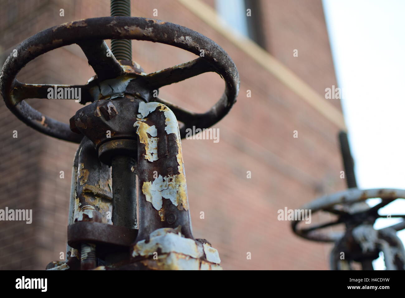 Old Rusty Clapet de décharge de pression des roues avec mur de brique en arrière-plan Banque D'Images