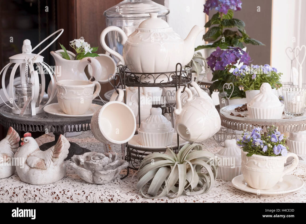 Céramique blanc typiques dans le style vintage avec mauve doux campanules sur différents EtagÃ¨re organisé, dans l'arrière-plan un hortensia, violet Banque D'Images