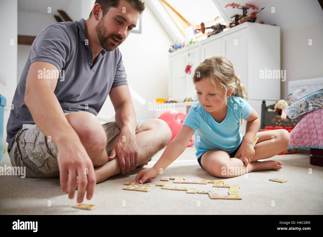 Père et fille jouer aux dominos ensemble, à la maison Banque D'Images