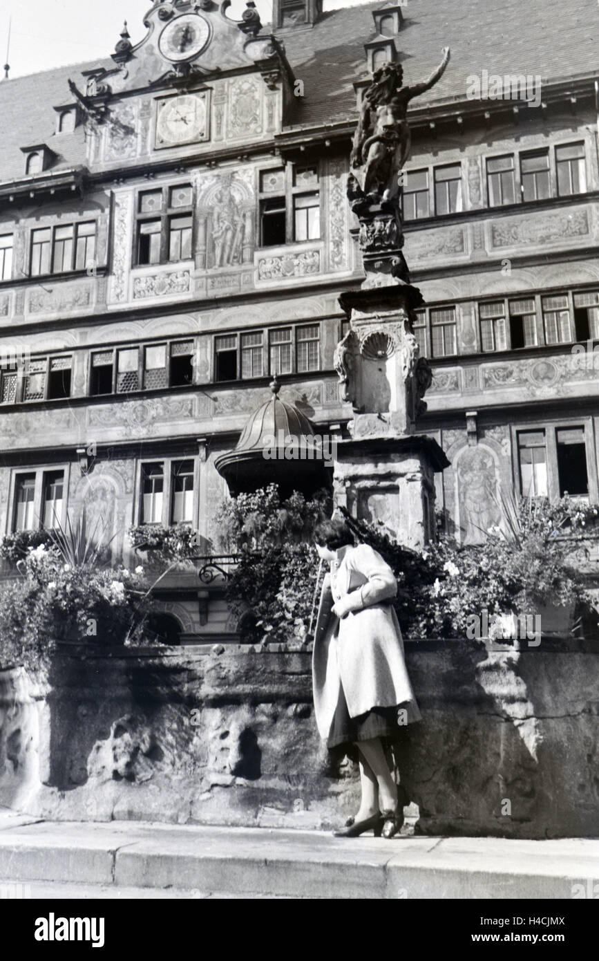 Eine junge Frau posiert vor dem Springbrunnen Am Marktplatz vor dem Tübinger Rathaus, Deutschland 1930 er Jahre. Une jeune femme est posant devant une fontaine à la place du marché en face de l'hôtel de ville de Tübingen, Allemagne, 1930 Banque D'Images