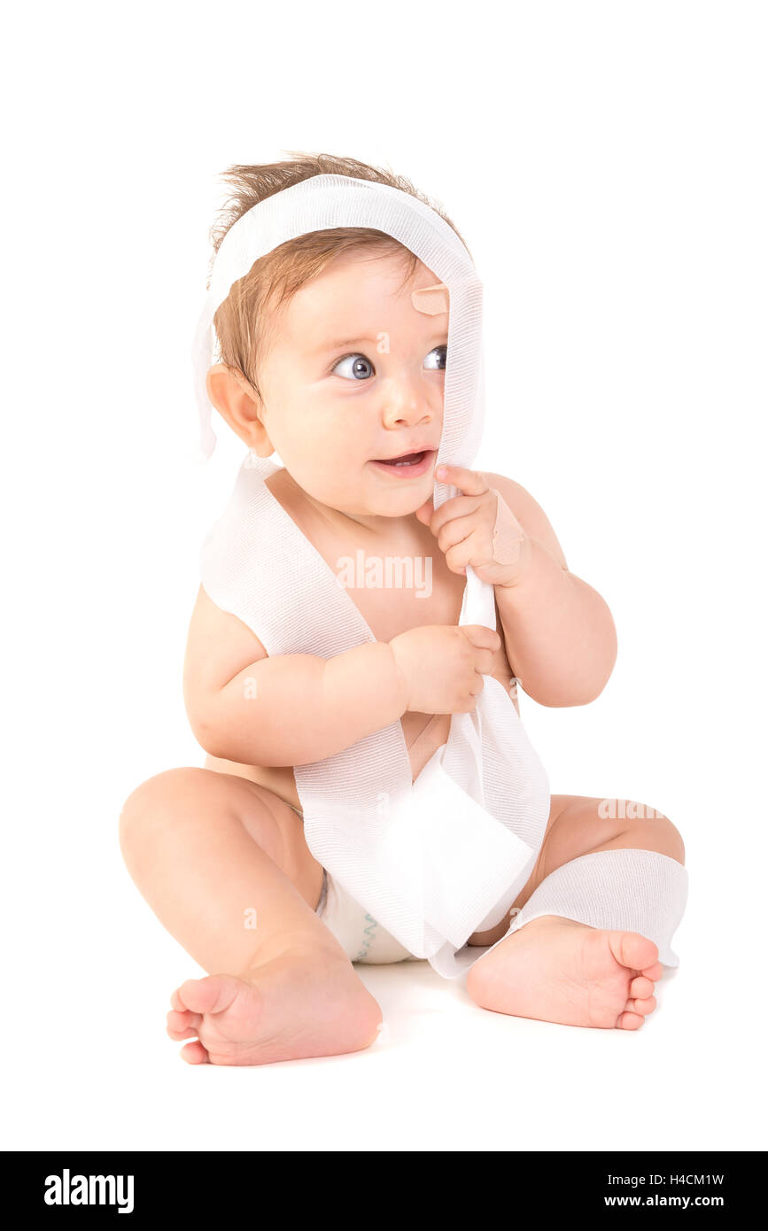 Mignon Bébé Garçon jouant avec des bandages Banque D'Images