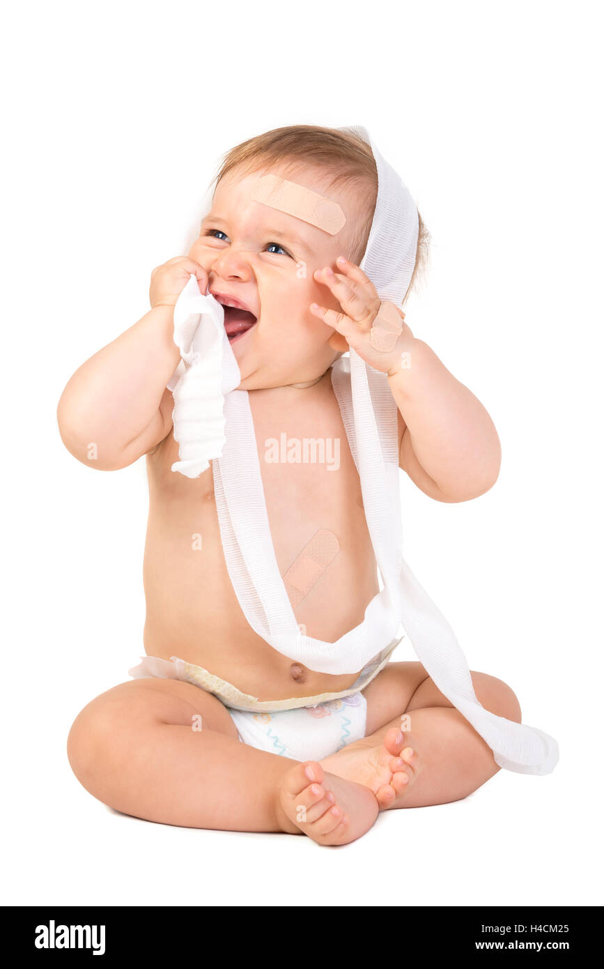 Mignon Bébé Garçon jouant avec des bandages Banque D'Images