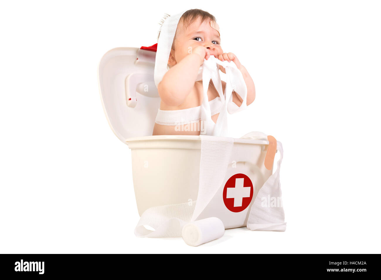 Mignon Bébé Garçon jouant avec des bandages dans une trousse de premiers soins. Banque D'Images