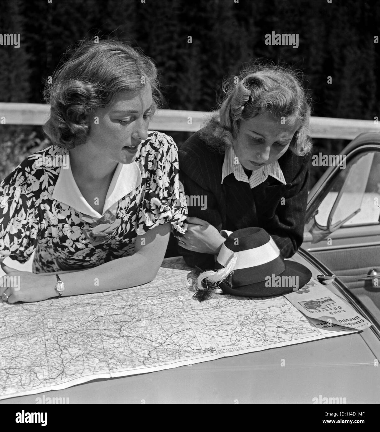 Zwei Frauen etudier die Straßenkarte auf der Motorhaube von Opel Olympia, Österreich 1930 er Jahre. Deux femmes la lecture de la carte routière sur le capot d'une Opel Olympia, Autriche 1930. Banque D'Images