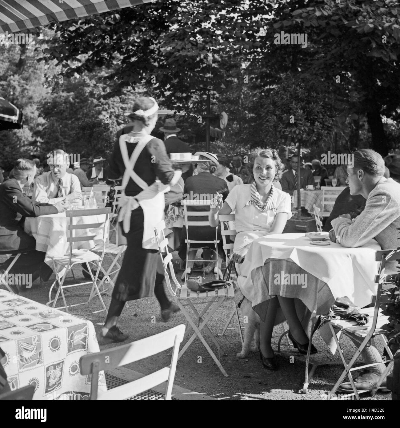 Menschen in einem Cafe à Stuttgart, Deutschland 1930er Jahre. Les gens à la terrasse d'un café à Stuttgart, Allemagne 1930. Banque D'Images