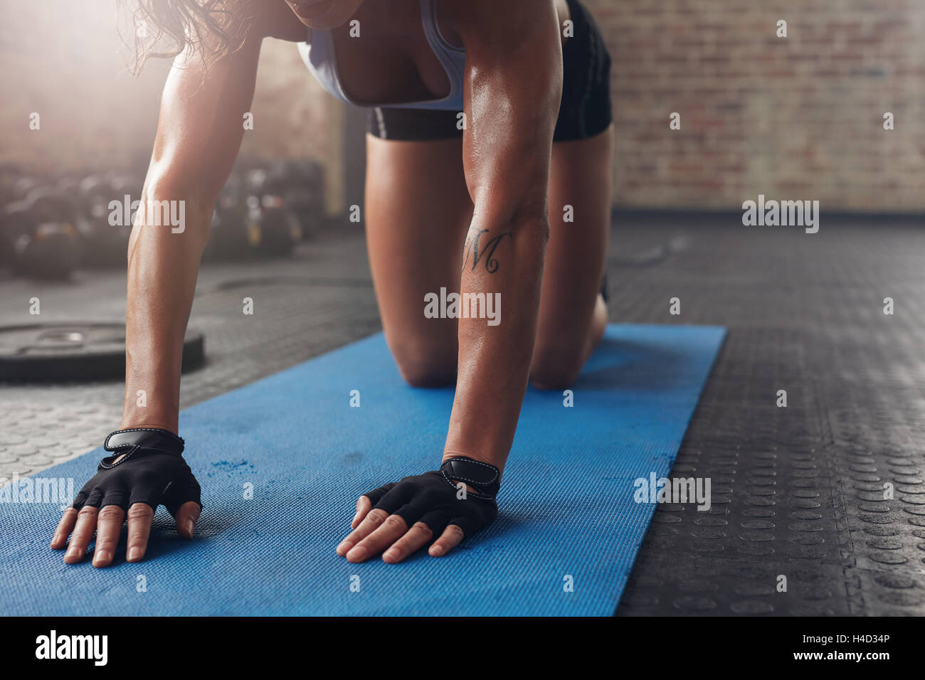 Sur les tapis d'exercice doing stretching entraînement. Se concentrer sur les mains d'une femme sur le tapis de fitness. Banque D'Images