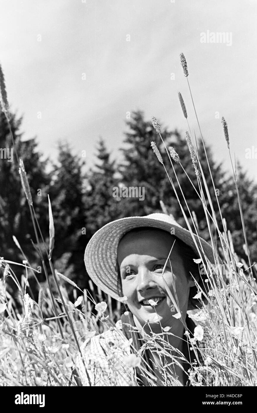 Porträt einer jungen Frau in einer Blumenwiese, Freudenstadt, Deutschland 1930 er Jahre. Portrait d'une jeune femme dans un champ de fleur, Freudenstadt, Allemagne 1930. Banque D'Images
