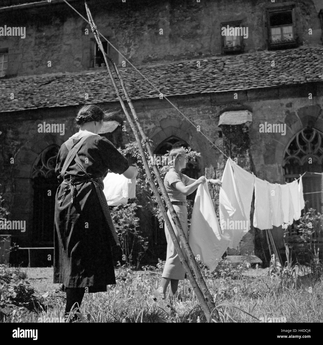 Zwei Frauen beim Wäsche aufhängen, Deutschland 1930 er Jahre. Deux femmes de raccrocher le lave-linge pour le séchage, l'Allemagne des années 1930. Banque D'Images