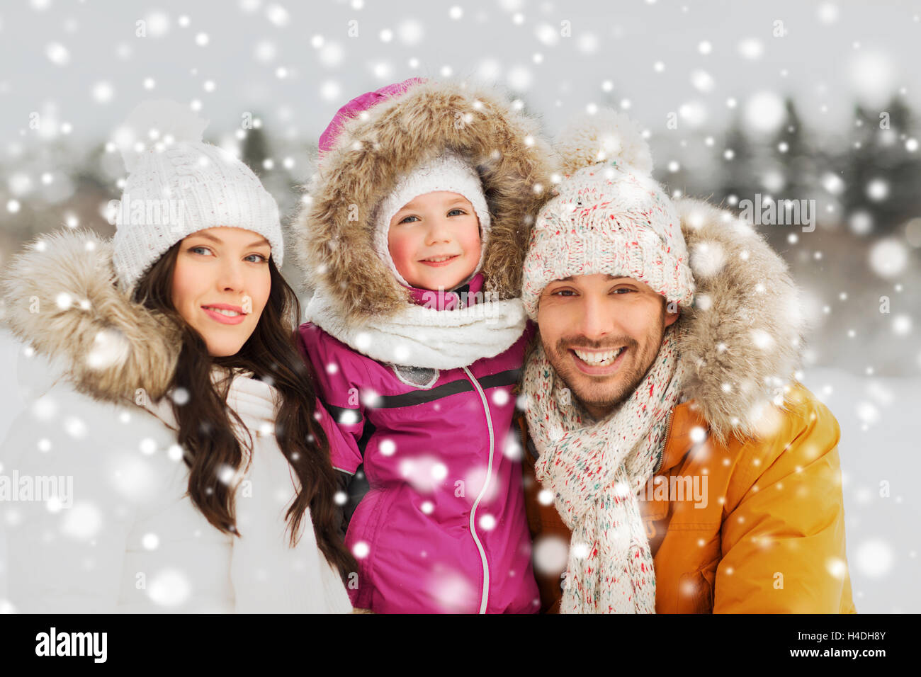 Famille heureuse avec l'enfant dans les vêtements d'hiver en plein air Banque D'Images