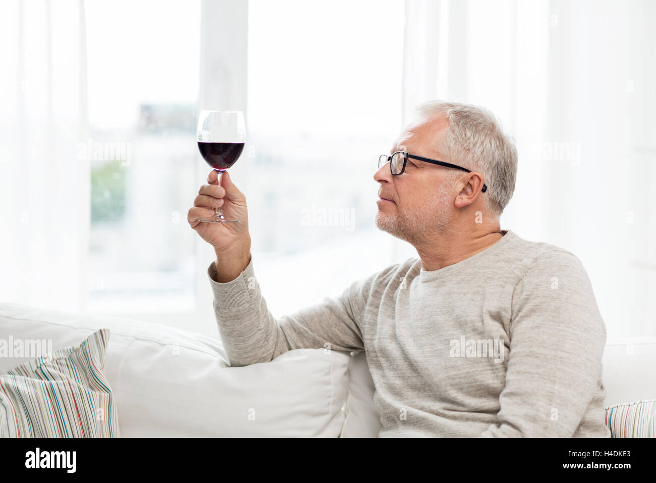 Senior man drinking red wine à partir du verre à la maison Banque D'Images