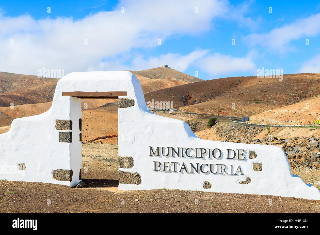 Panneau municipal typique (arche blanche porte) près de Betancuria village avec désert paysage de montagne dans l'arrière-plan, Fuerteventura, Îles Canaries, Espagne Banque D'Images