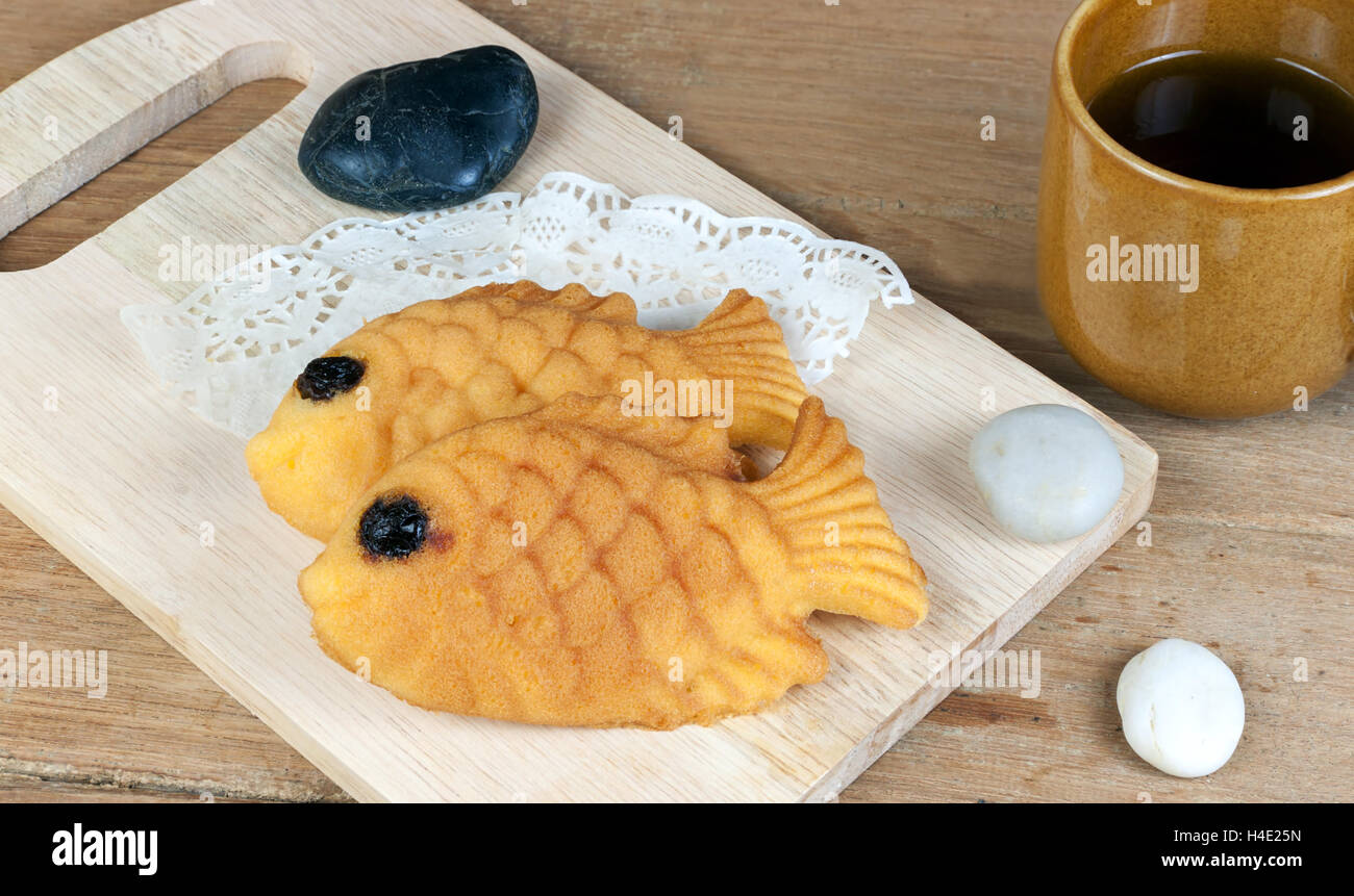 Taiyaki, japonais en forme de poisson crêpe. Mangé avec du thé chaud sur la table en bois Banque D'Images