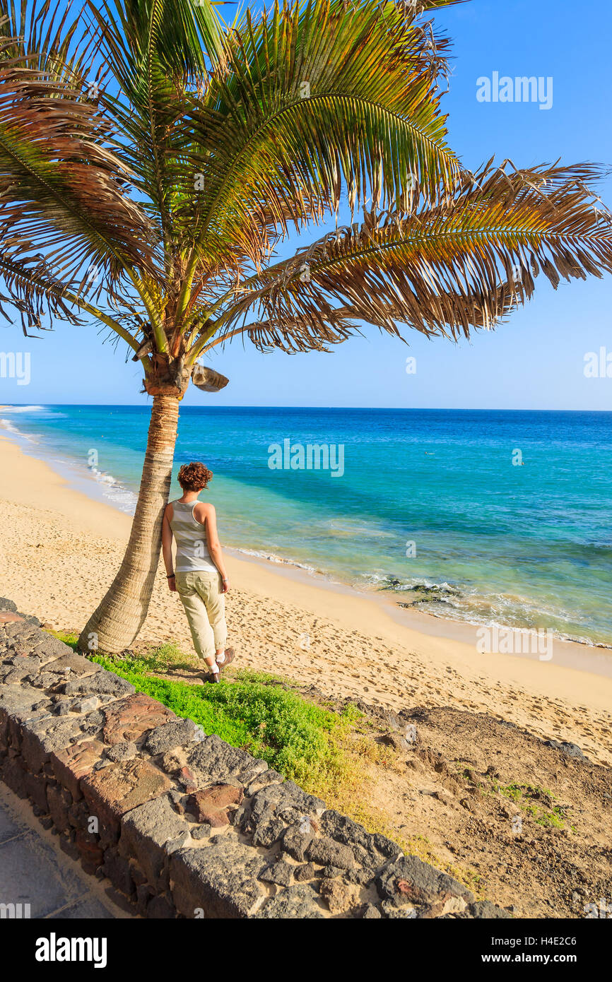Les jeunes touristes womand sous palmier ressemble à Morro Jable plage sur la Péninsule de Jandia, Fuerteventura, Îles Canaries, Espagne Banque D'Images