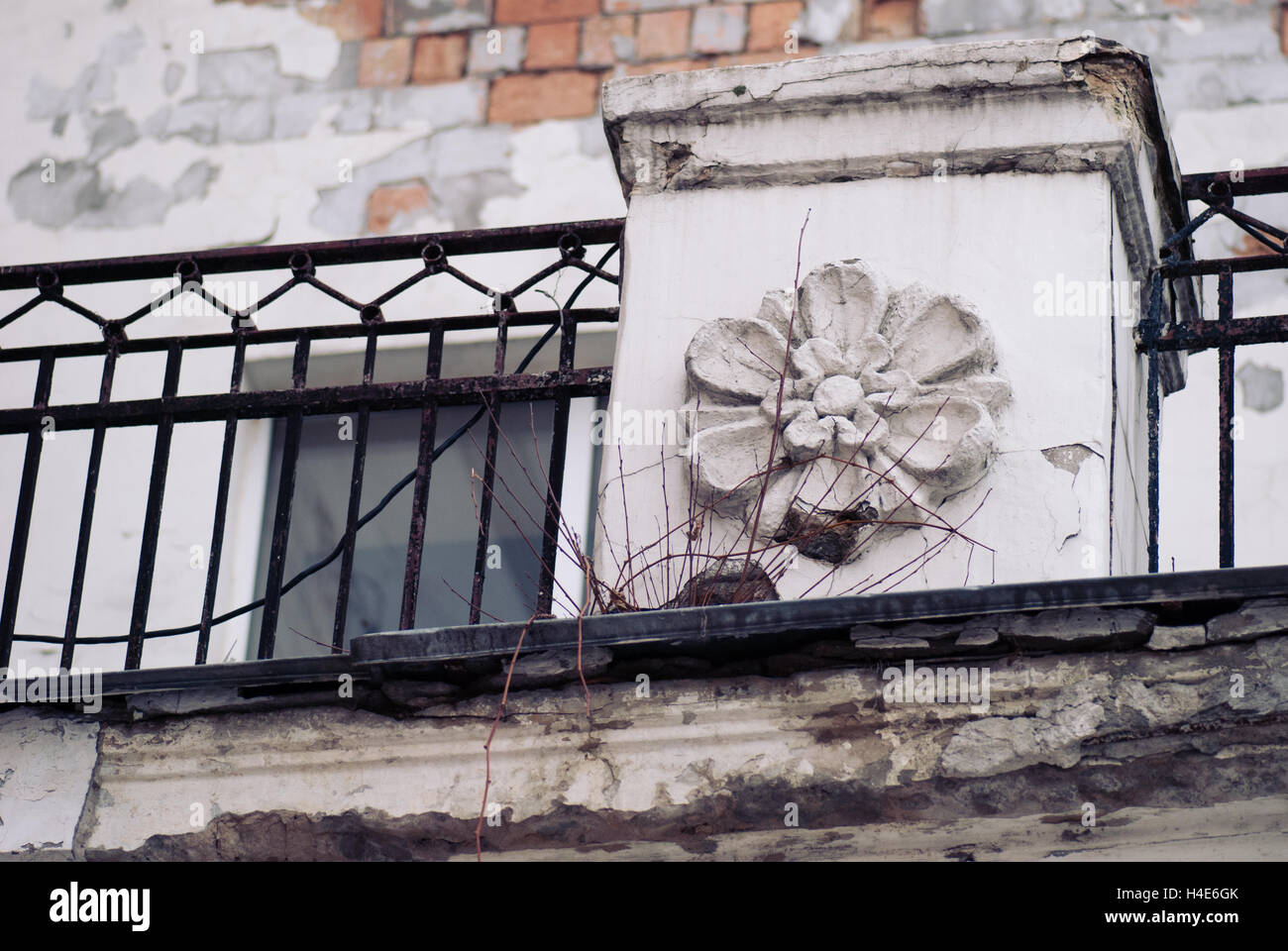 Vieille maison abandonnée avec des fragments de peinture pelée sur le mur et de fer fincing, moulage en fonte fleur pleine de fissures Banque D'Images