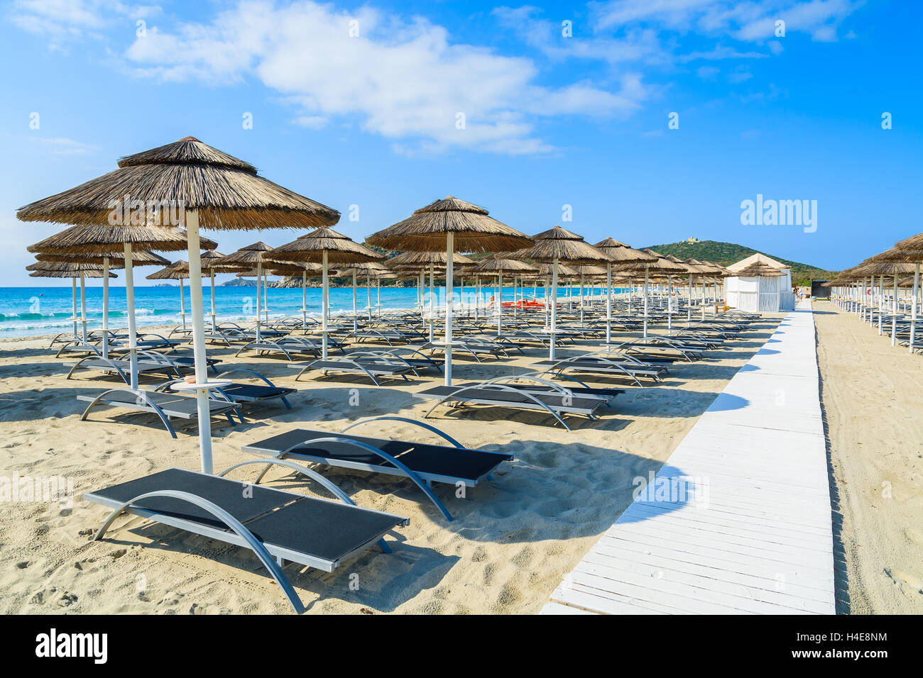 Chemin le long de chaises longues avec parasols sur la plage de sable blanc dans la baie de Porto Giunco, Sardaigne, île, Italie Banque D'Images