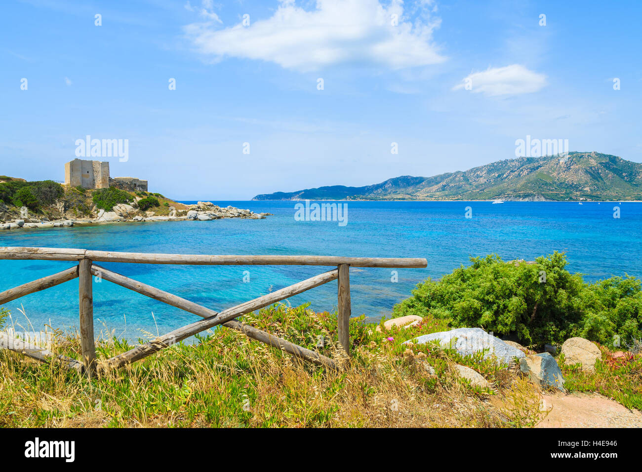 Clôture en bois sur les côtes de Sardaigne, île de la mer d'azur et château en arrière-plan, près de Porto Giunco, port Italie Banque D'Images