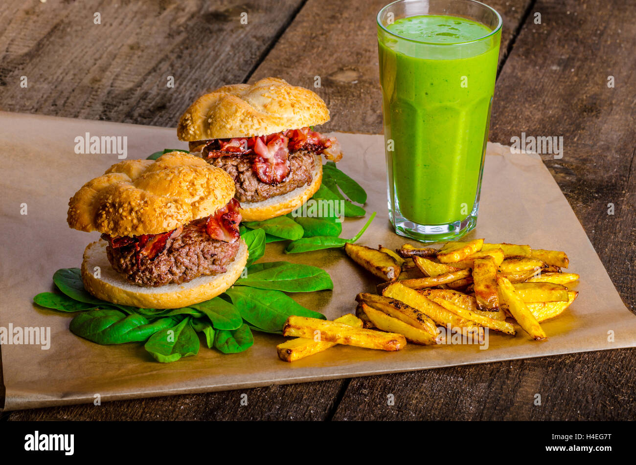 Bacon burger avec frites et herbes chili banana smoothie sur table en bois Banque D'Images Bacon burger avec frites et herbes chili banana smoothie sur table en bois Banque D'Images