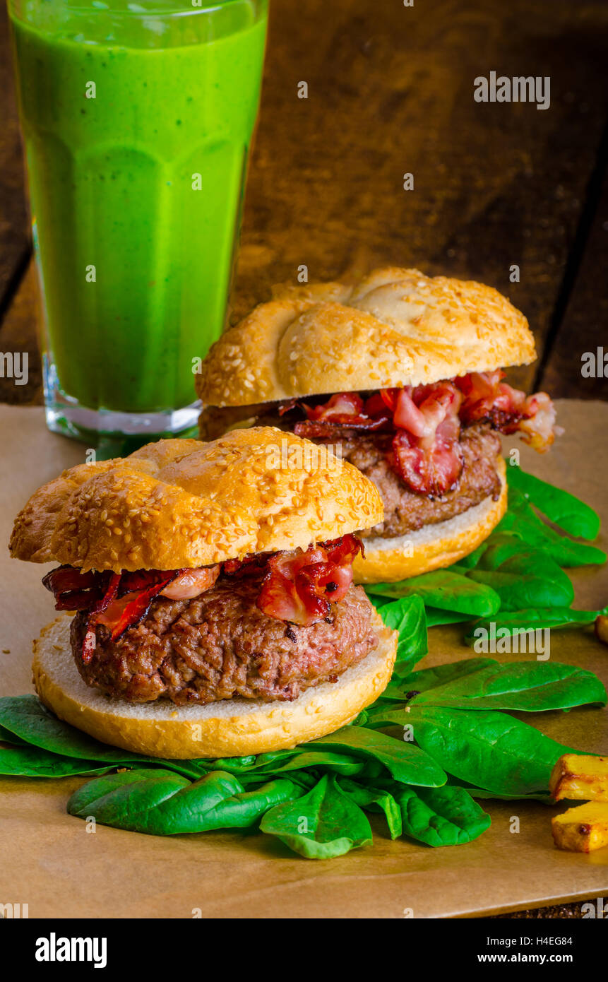 Bacon burger avec frites et herbes chili banana smoothie sur table en bois Banque D'Images Bacon burger avec frites et herbes chili banana smoothie sur table en bois Banque D'Images