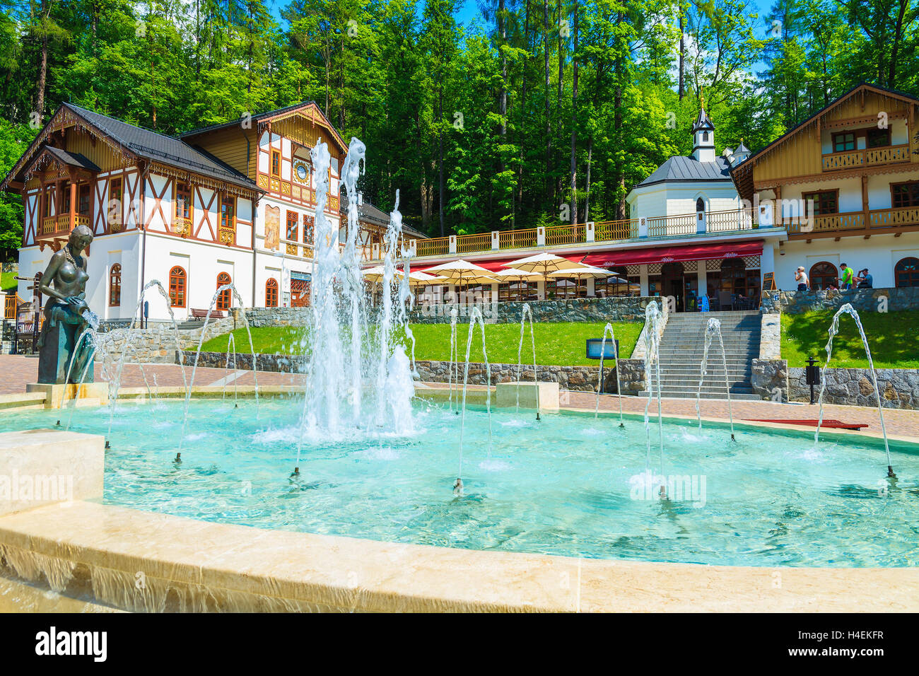 SZCZAWNICA, POLOGNE - JUN 10, 2014 : fontaine à eau dans un parc avec des bâtiments historiques de la ville de Szczawnica centre ville, Pologne. De nombreux Polonais viennent ici recevoir des soins de santé en raison de la bonne ambiance. Banque D'Images