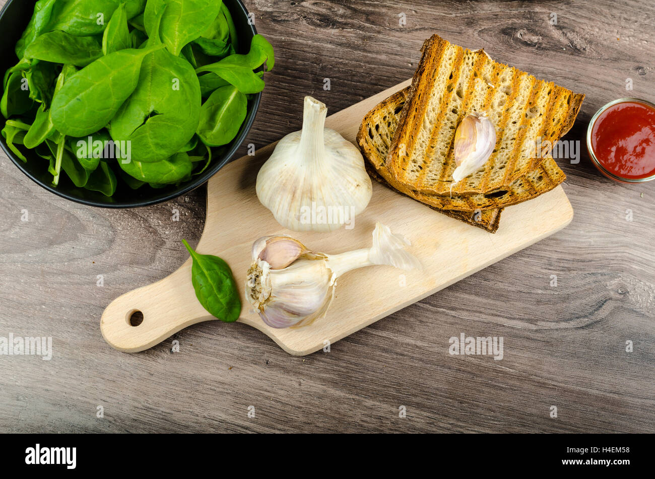 Les ailes de poulet avec du pain à l'ail panini, pommes de terre épicées rustique, feuilles d'épinards fraîches Banque D'Images