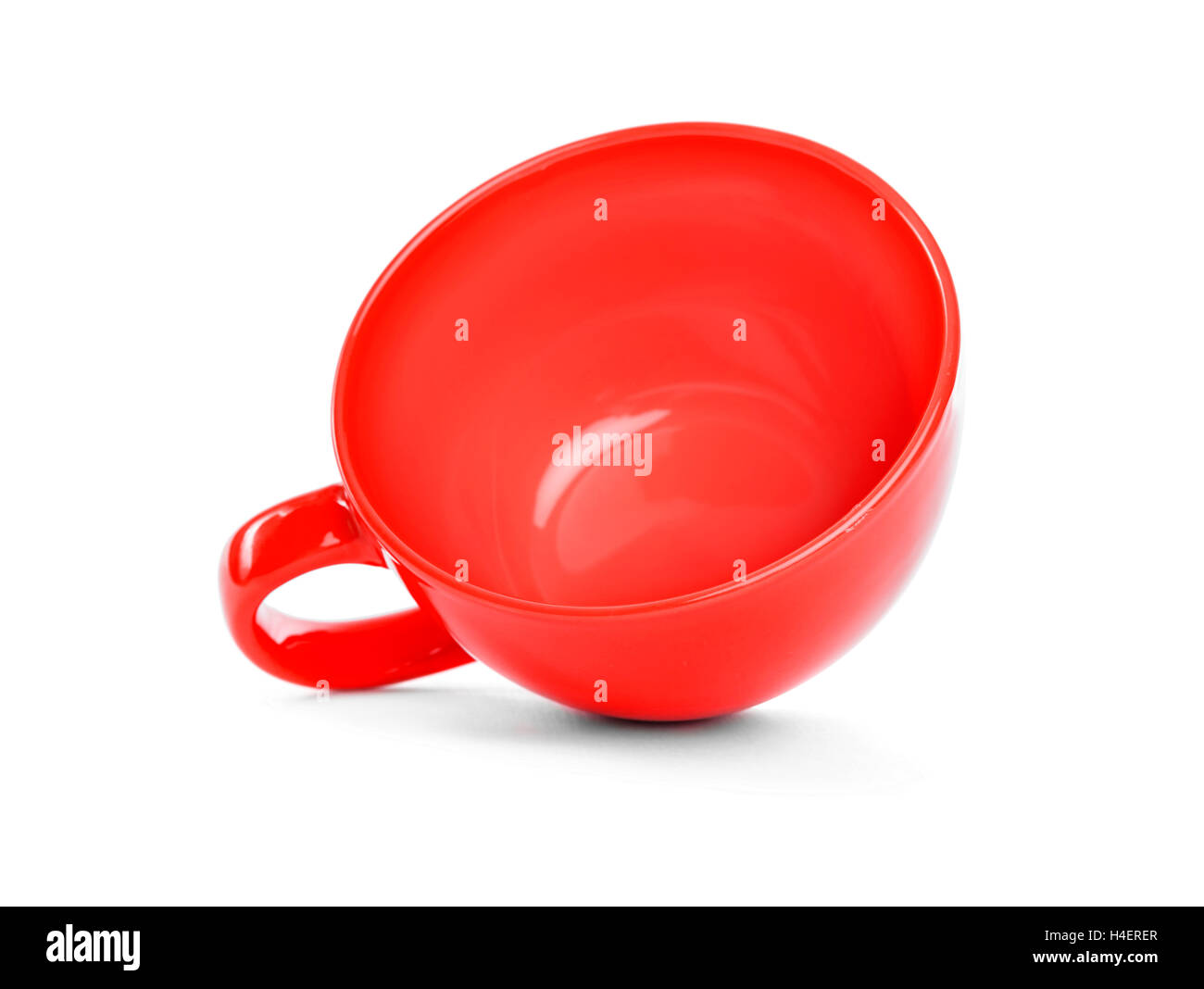 Tasse rouge se trouve sur un fond blanc. Banque D'Images