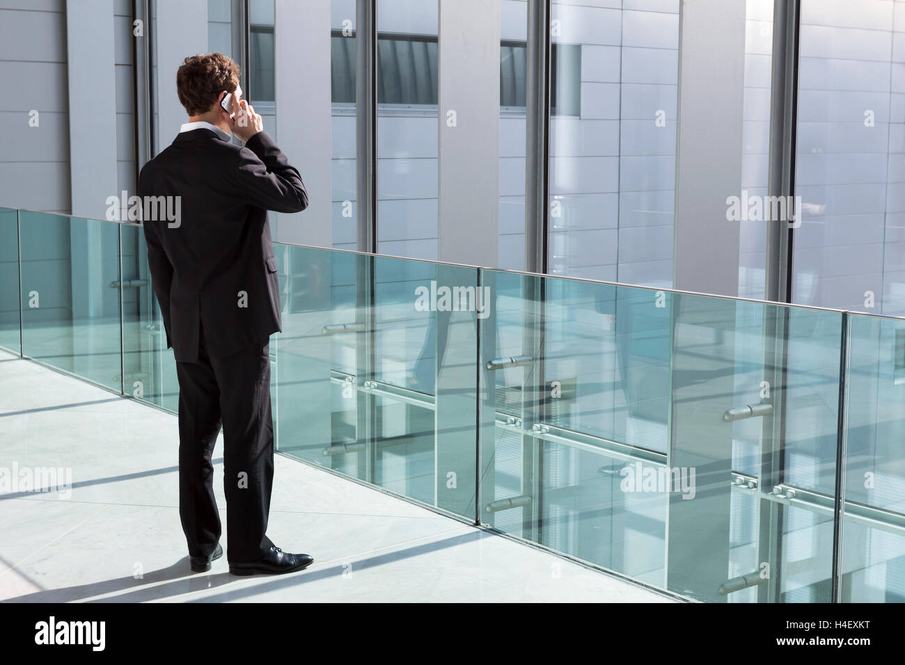 Businessman phoning avec nouvelle technologie smartphone dans immeuble de bureaux modernes Banque D'Images
