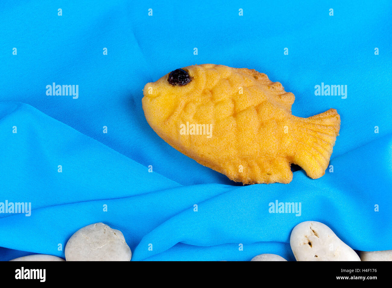 Taiyaki, japonais en forme de poisson sur crêpe chiffon bleu et rock-arrondies. Banque D'Images
