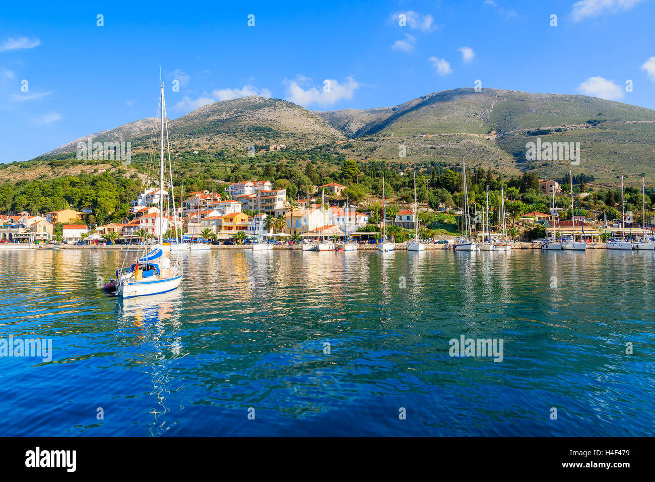 Location de bateau sur le bleu de la mer et vue sur le village de pêcheurs d''Agia Efimia avec le port, l'île de Céphalonie, Grèce Banque D'Images