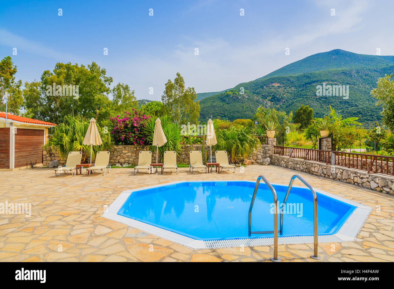 Petite piscine avec transats dans paysage de montagnes de l'île de Céphalonie, Grèce Banque D'Images