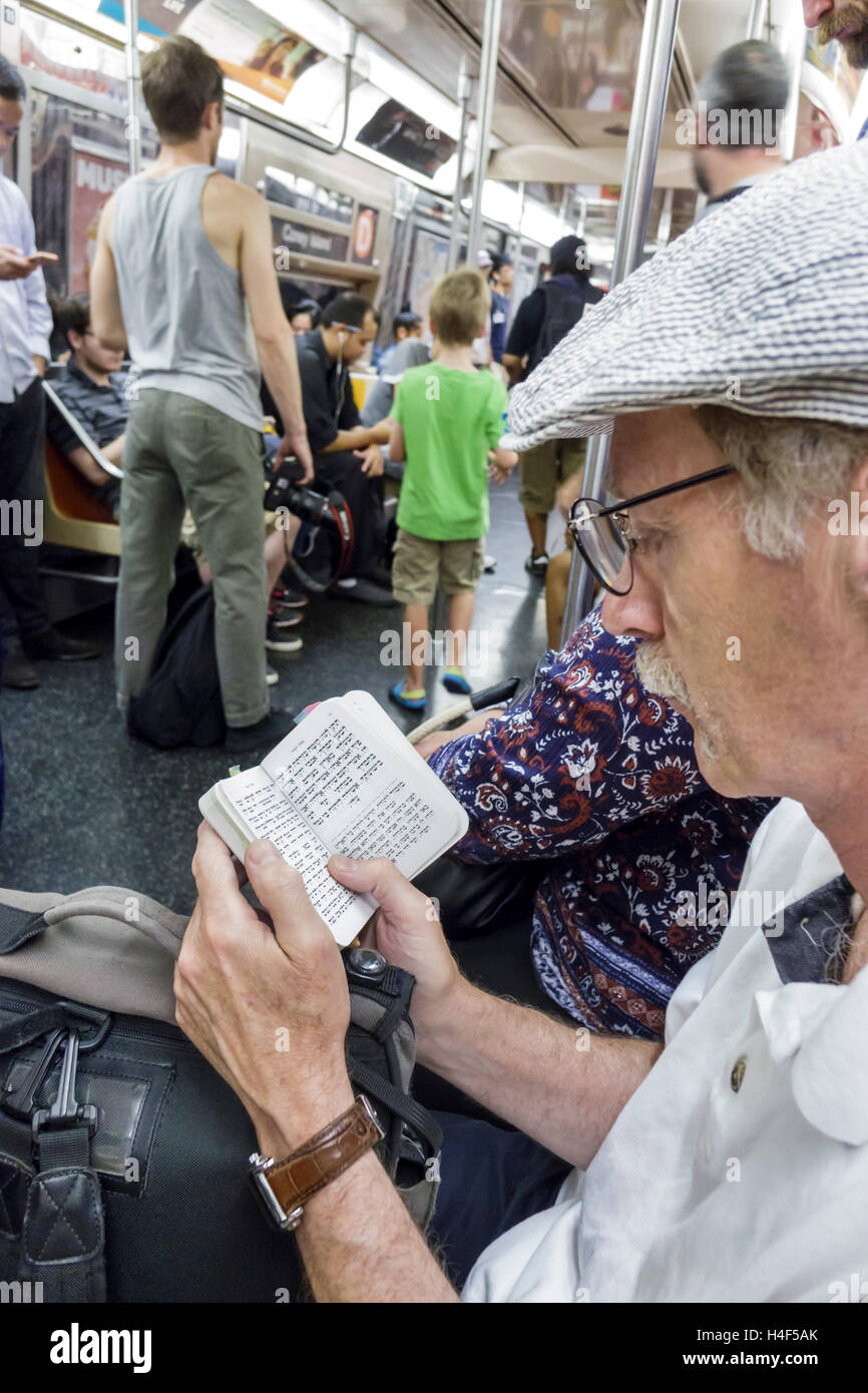 New York City,NY NYC Lower Manhattan,Chinatown,métro,train,MTA,passagers rider riders,assis,lecture,hébreu,livre,langue,adulte,adultes,ma Banque D'Images