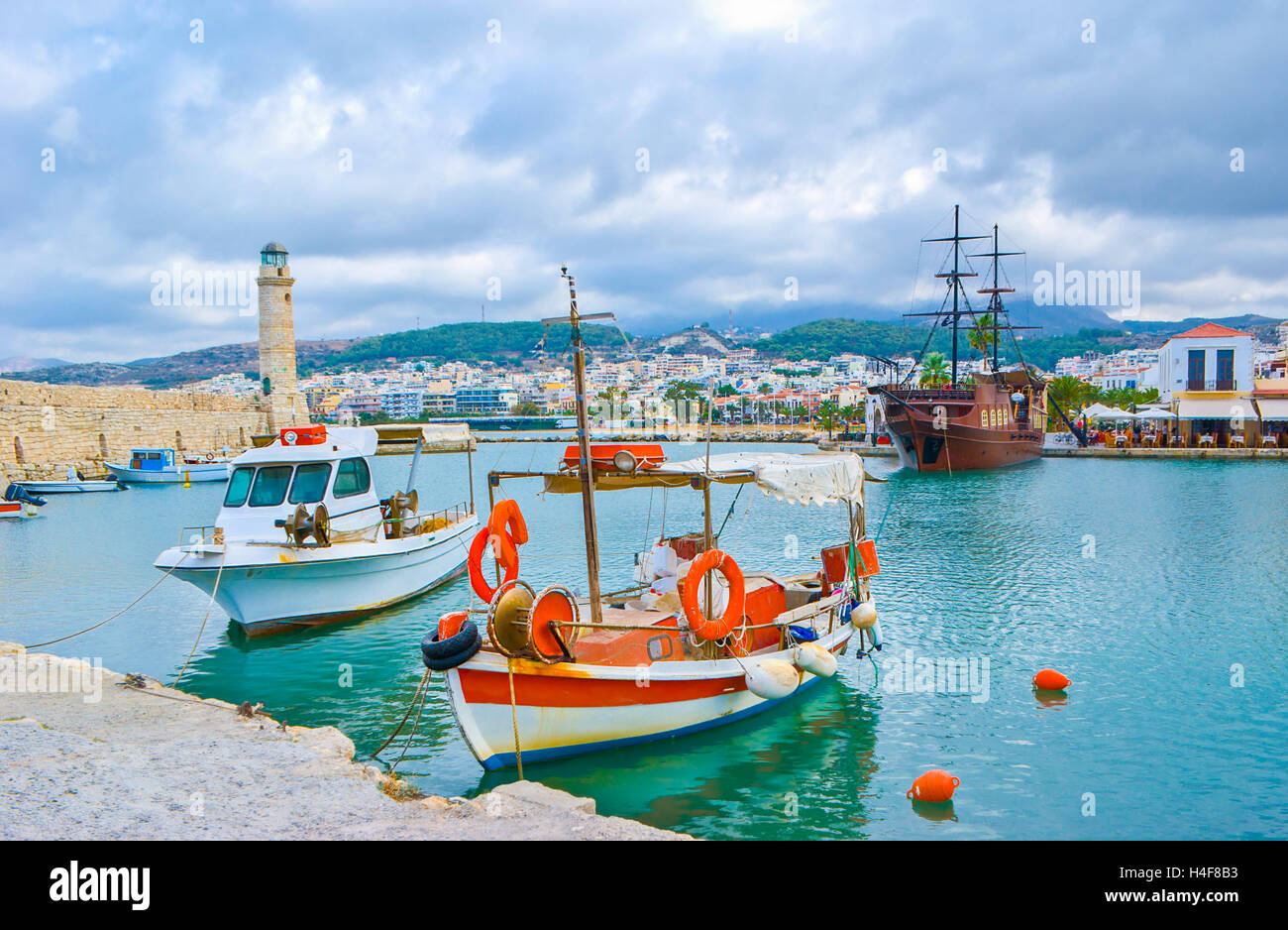 Les bateaux de pêche dans le vieux port vénitien de Réthymnon avec la réplique de guerre médiévale sur l'arrière-plan, Crète, Grèce. Banque D'Images