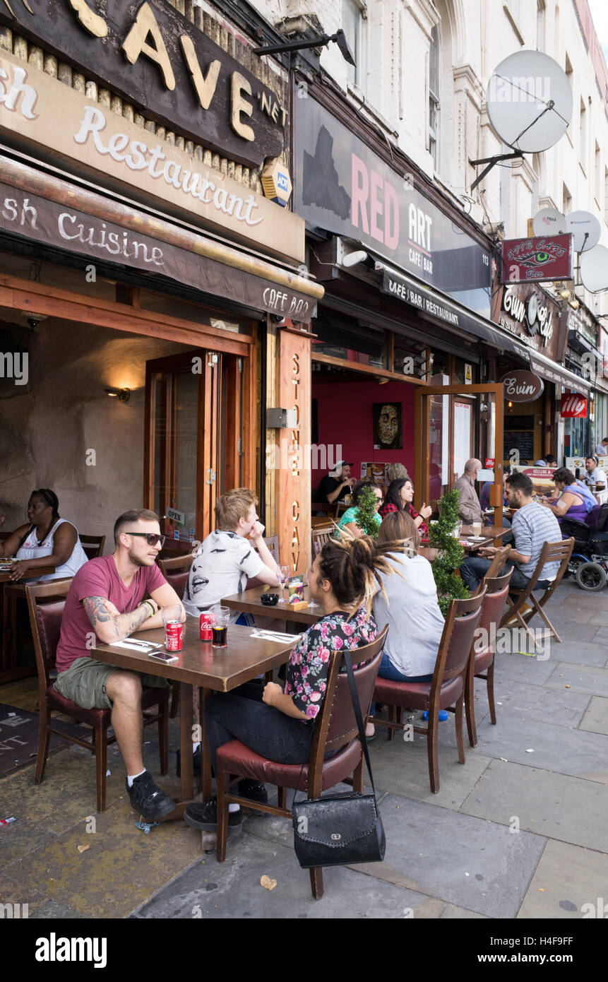 Les gens assis à des tables de cafés et restaurants sur Kingsland High Street, Dalston, Hackney, Londres, Angleterre, RU Banque D'Images