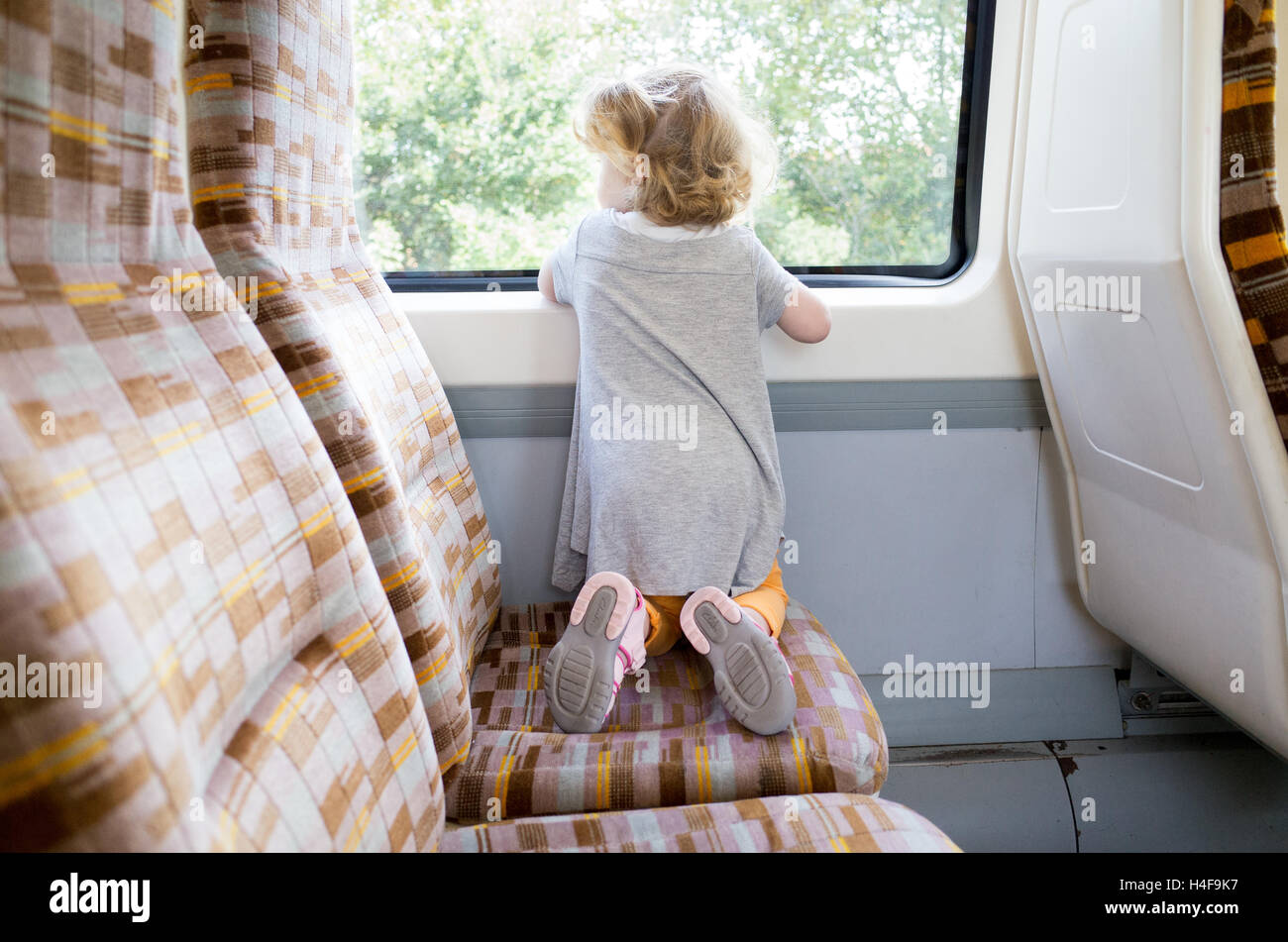 Jeune enfant de deux ans voyageant sur un train terrestre de Londres, Angleterre, Royaume-Uni Banque D'Images