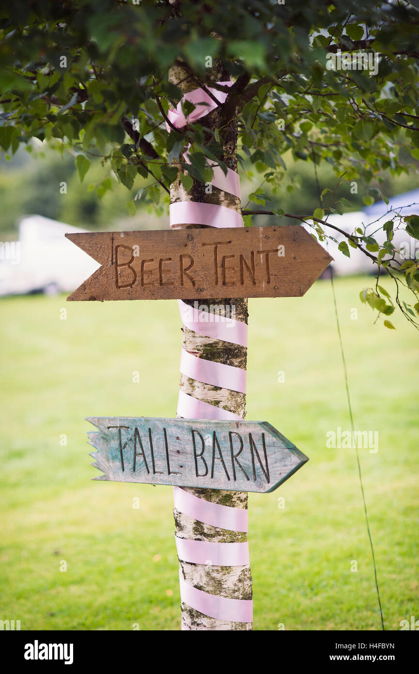 Flèches en bois cloué à un arbre, signe de la tente à bière mariage festival rustique Banque D'Images