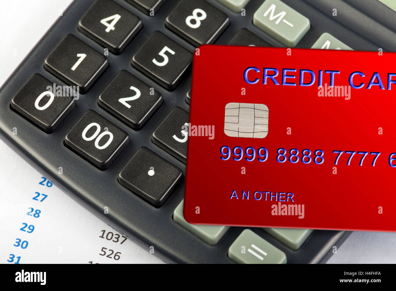 Carte de crédit rouge portant sur un clavier de calculatrice à l'aide d'un tableur sur show Banque D'Images