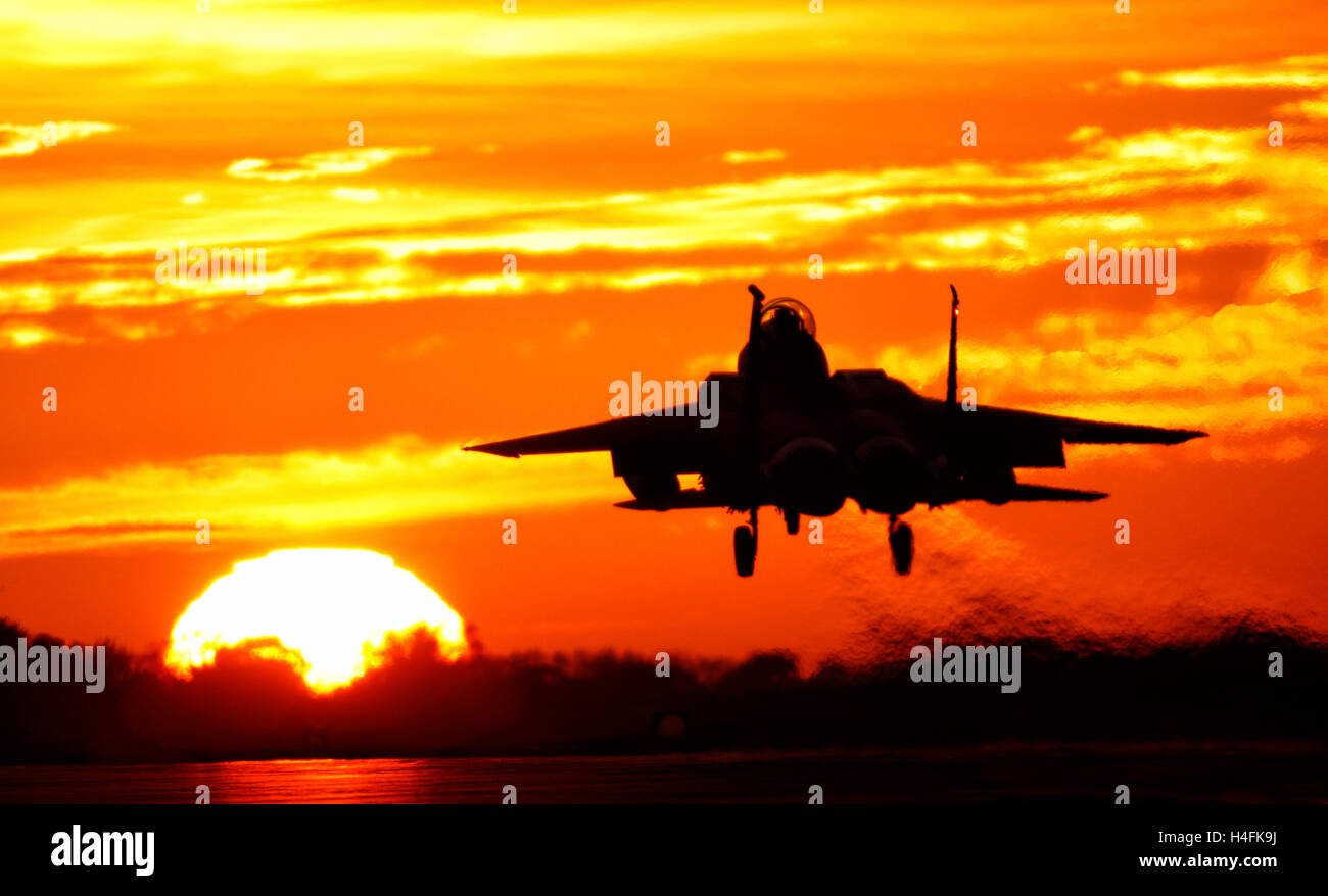 F-15E Strike Eagle United States Air Force à l'atterrissage à RAF Lakenheath Suffolk UK contre un coucher de soleil orange Banque D'Images