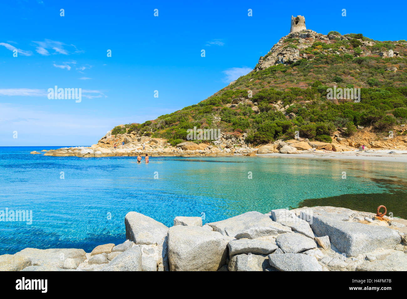 Deux ou trois personnes non identifiées la natation dans la mer d'azur bay près de Torre de Porto Giunco, tour de l'île de la Sardaigne, Italie Banque D'Images