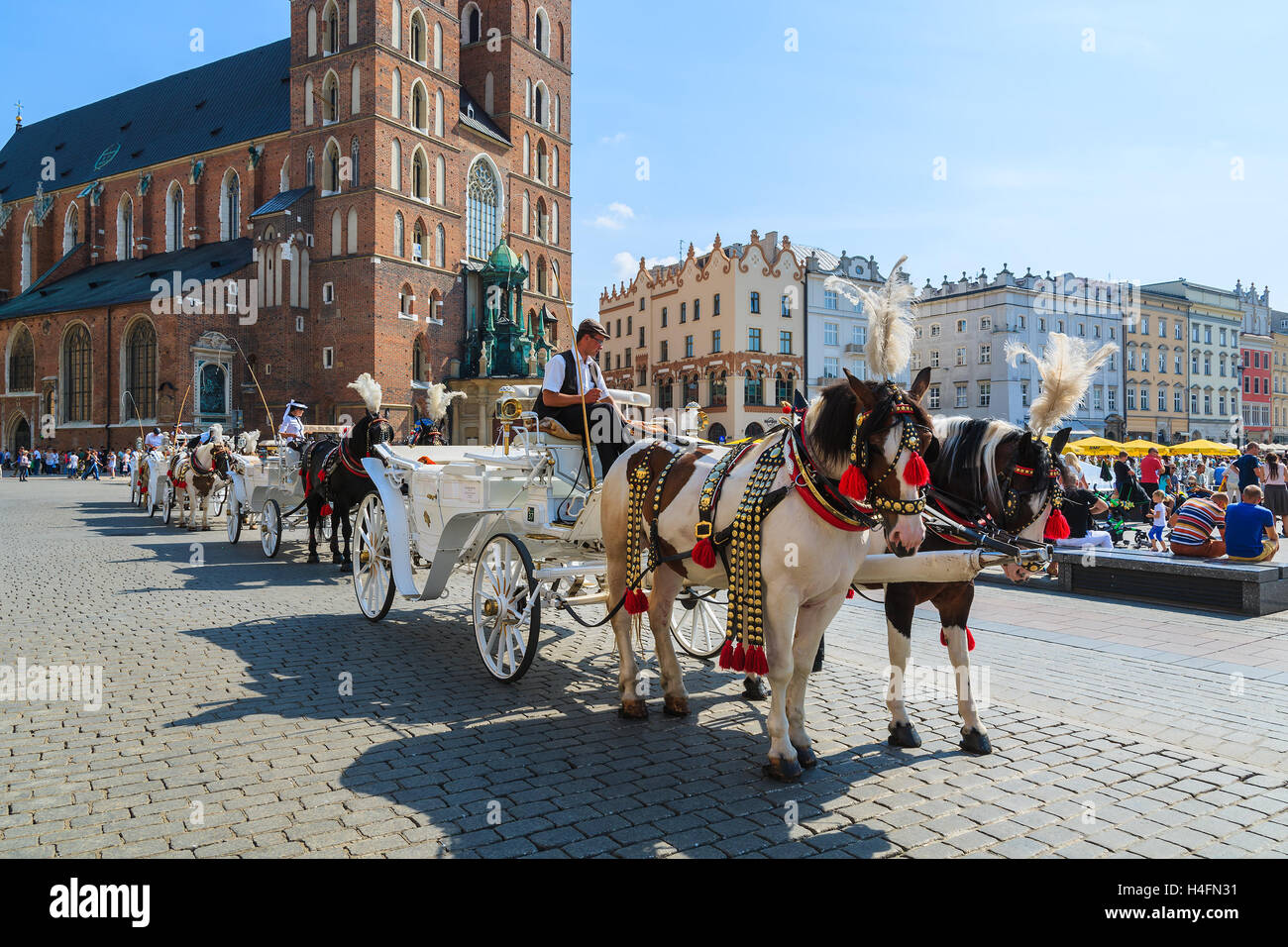 Cracovie, Pologne - 7 SEP 2014 : voitures à cheval en face de l'église Mariacki sur la place principale de la ville de Cracovie. Prendre un tour de cheval en calèche est très populaire parmi les touristes visitant Cracovie. Banque D'Images