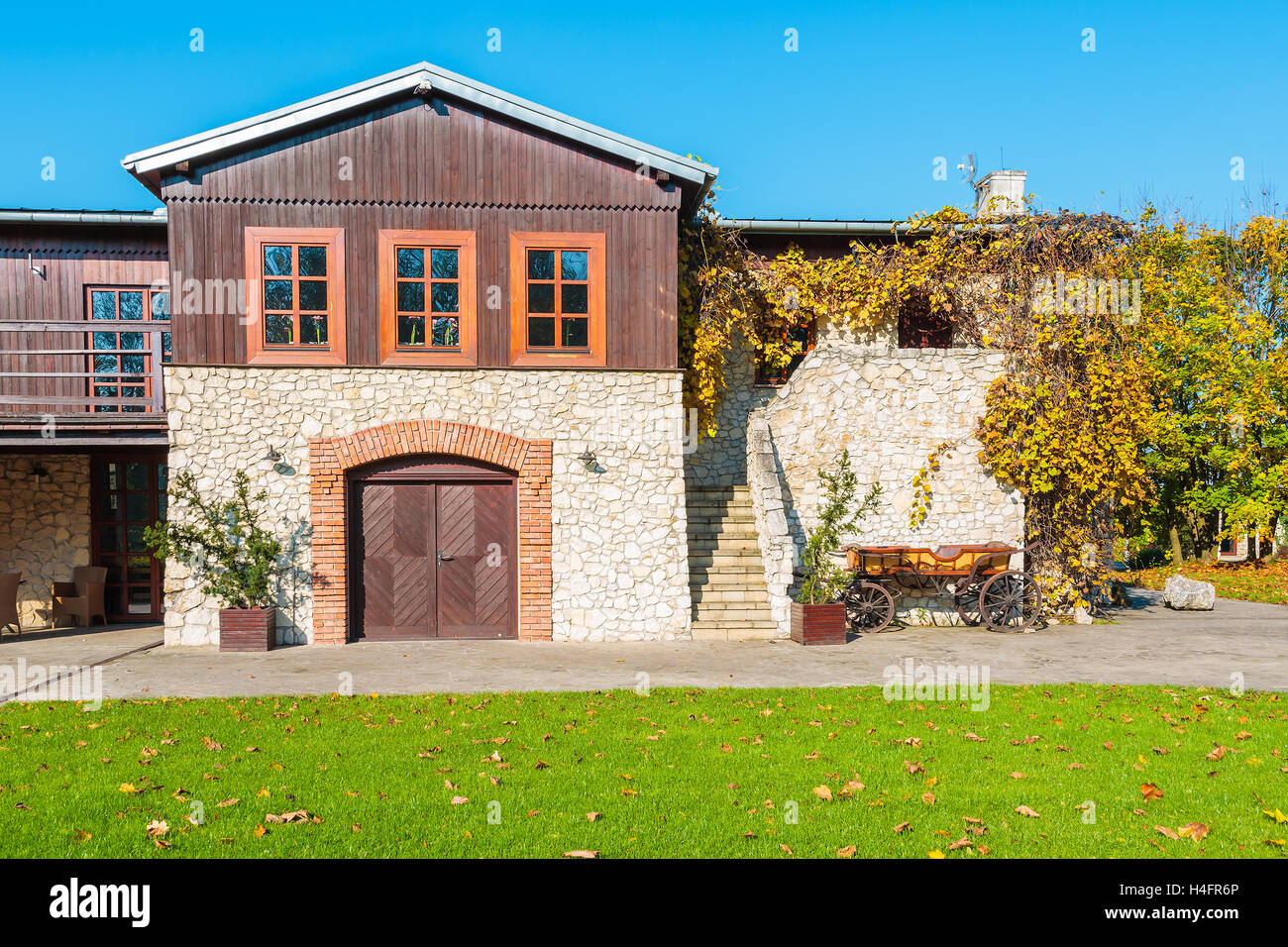 Pelouse verte et maison traditionnelle à Tomaszowice village park par beau jour d'automne, Pologne Banque D'Images