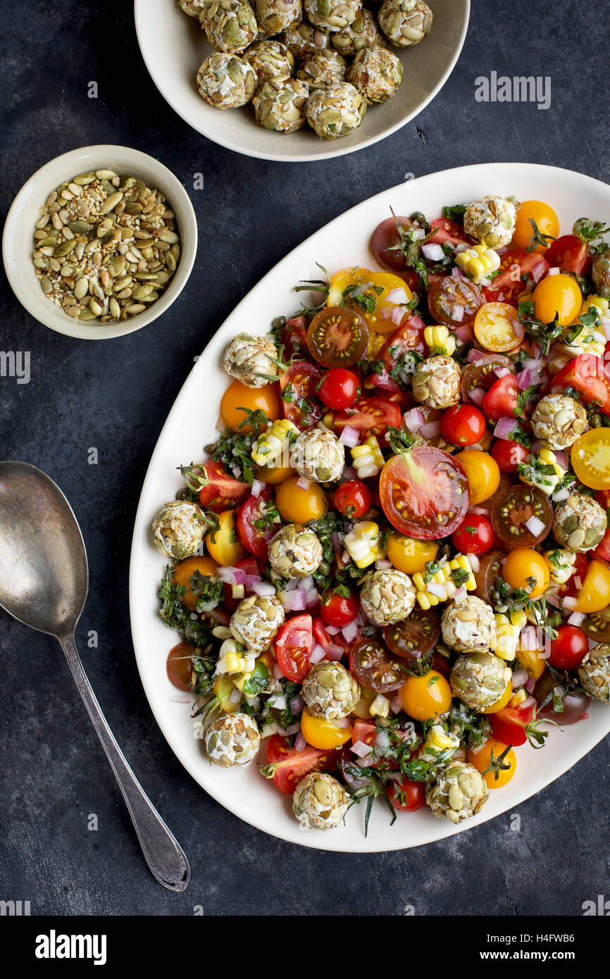 Salade de tomates cerises d'héritage avec des têtes de chevre servi avec du vin blanc et du pain croustillant. En vue de dessus sur Photograpghed Banque D'Images